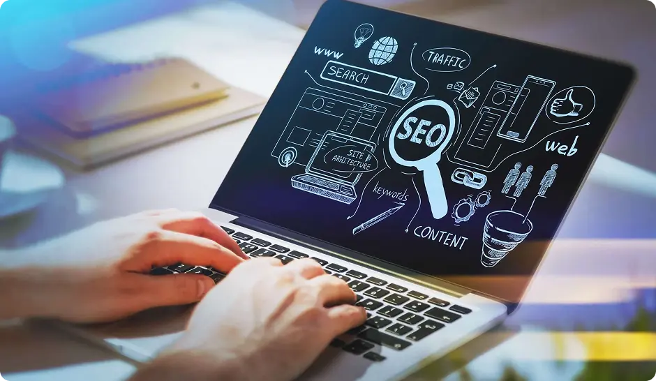 Hands typing on a laptop displaying SEO concepts like keywords, traffic, and content strategy.